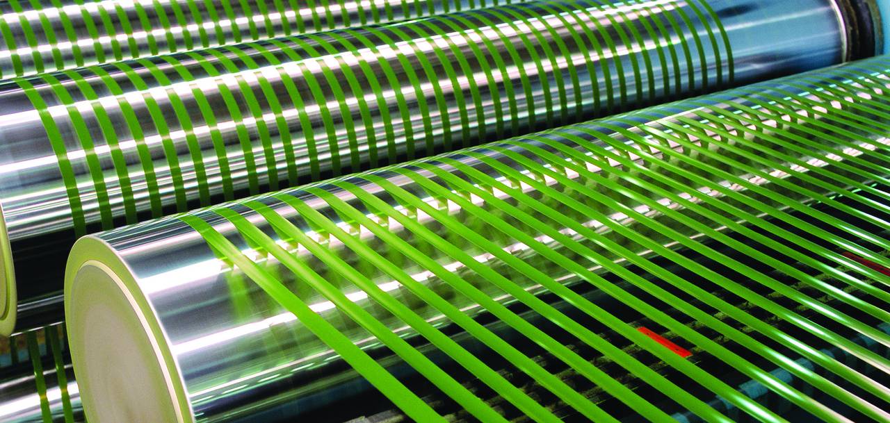 Spools of green turf yarn on the extrusion line at APT's Melbourne factory